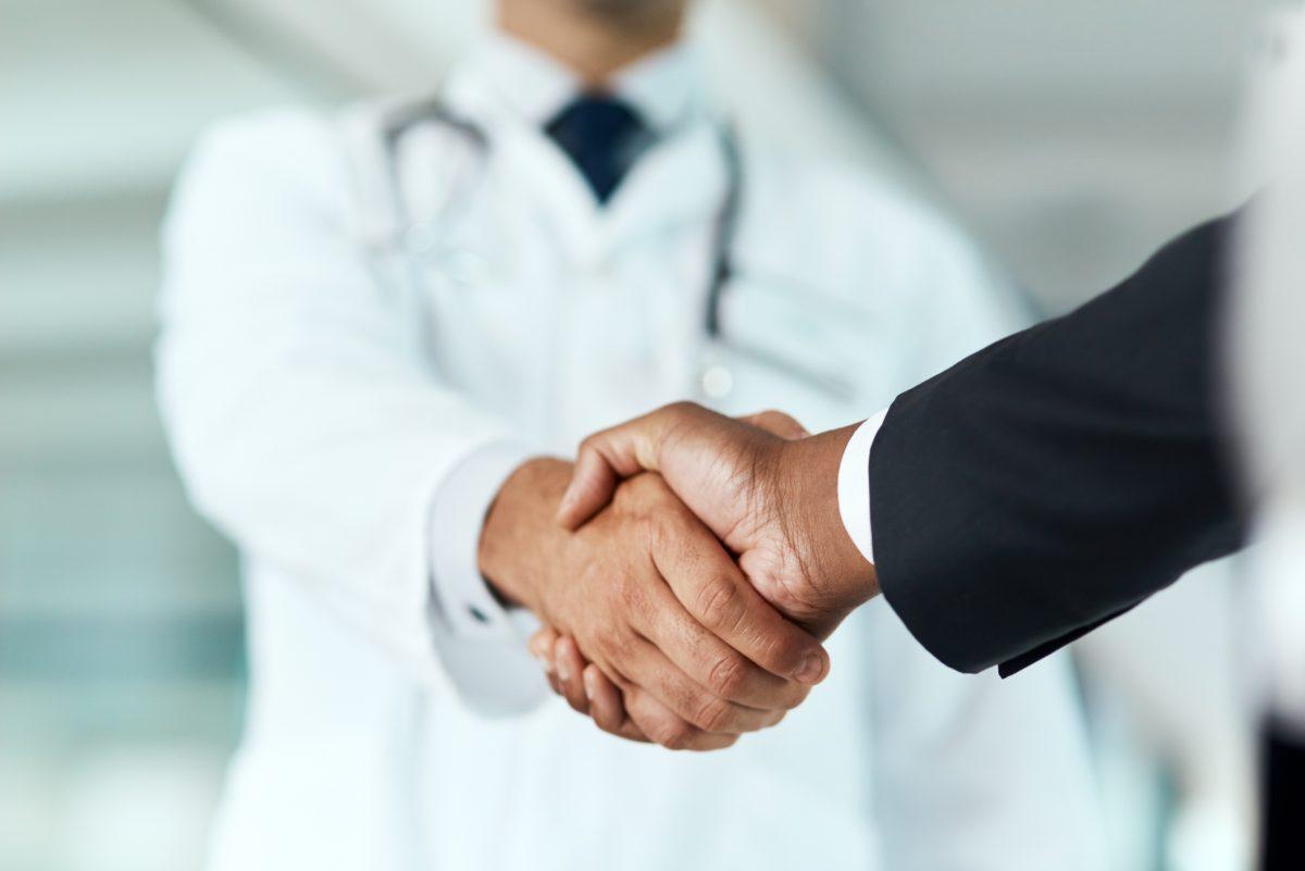 Cropped shot of a doctor shaking hands with a businessman in a hospital